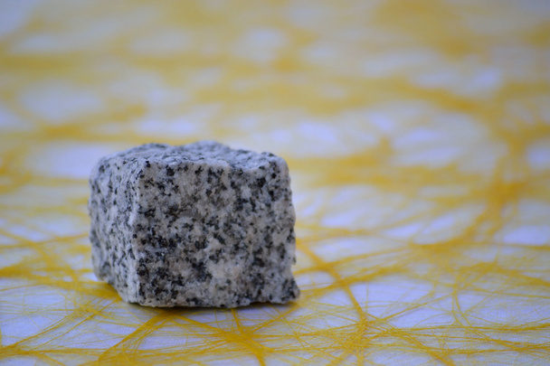 Piedra natural sobre mantel amarillo
 - Foto, imagen