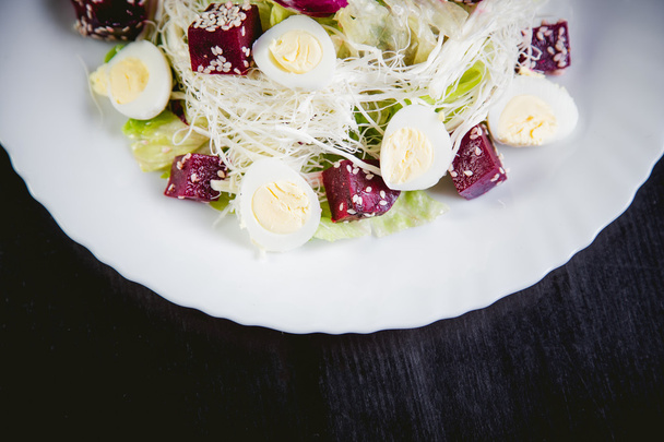 Buriak salad, greens and perepelin?h eggs, sesame - Foto, Imagen