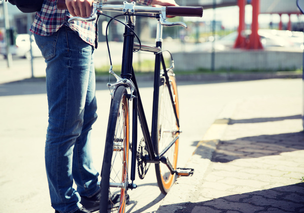 close up of man and fixed gear bike on city street - Фото, изображение