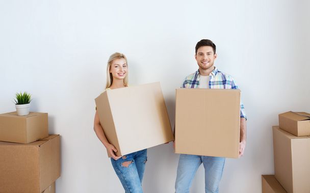 smiling couple with big boxes moving to new home - Fotografie, Obrázek