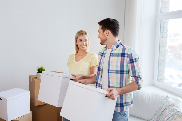 smiling couple with big boxes moving to new home - Photo, Image