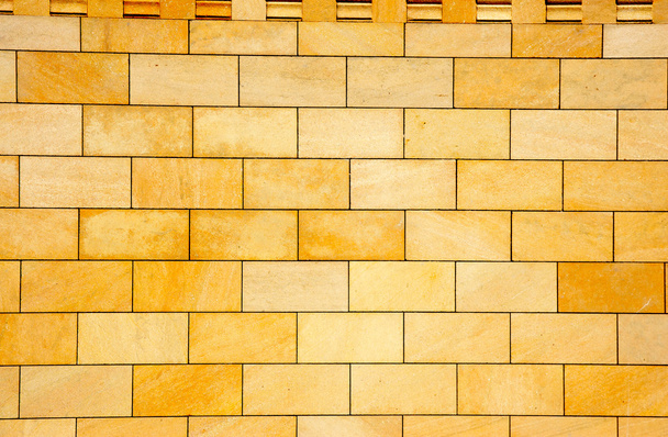 стіну облицьовують жовтою плиткою
 - Фото, зображення