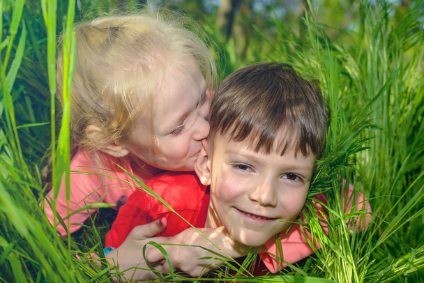 Amusant aimant petit garçon et fille dans l'herbe verte longue
 - Photo, image