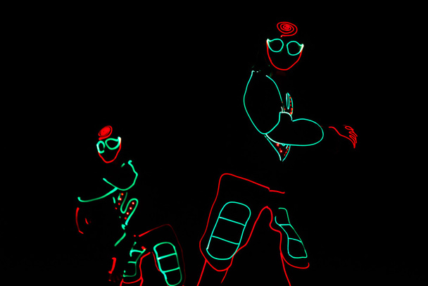 danseurs en costumes led sur fond sombre, spectacle coloré
 - Photo, image
