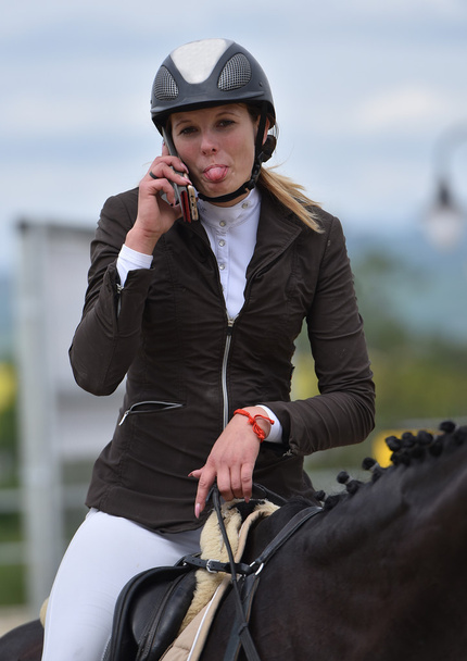 mulher usando smartphone enquanto monta cavalo
 - Foto, Imagem