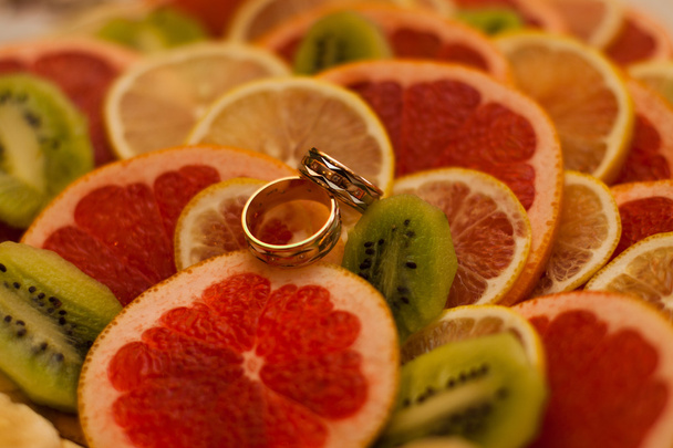 dois anéis de casamento em laranjas
 - Foto, Imagem