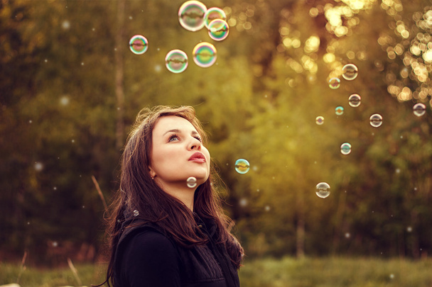 Young girl blowing soap bubbles. - Φωτογραφία, εικόνα