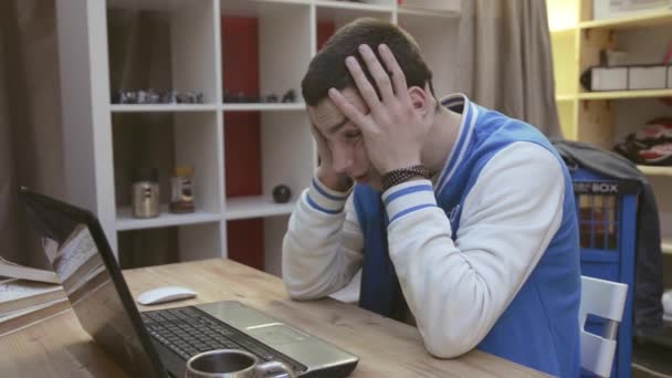 Giovane ragazzo in giacca sportiva blu sbadigliare sullo schermo anteriore del taccuino in camera. Sonnolenza. Stanchezza
 - Filmati, video