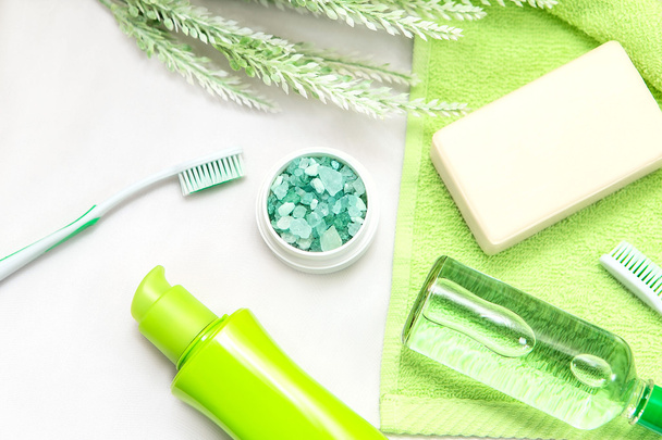 Akcesoria łazienkowe na zielony ręcznik. Szczoteczki do zębów, mydło i płyn. - Zdjęcie, obraz