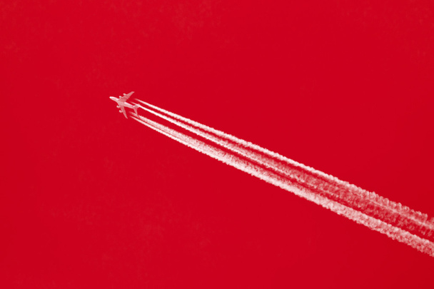 Αεροπλάνο στο μπλε του ουρανού - φωτεινό κόκκινο ουρανό - Φωτογραφία, εικόνα