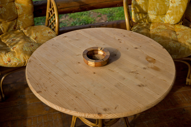 Cinzeiro de madeira em uma mesa redonda de madeira 02
 - Foto, Imagem