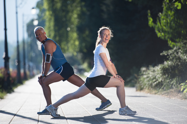 couple warming up and stretching before jogging - Fotoğraf, Görsel