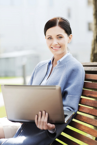 smiling business woman with laptop in city - Foto, Imagem