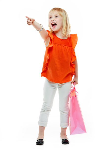 Girl with shopping bag on white background pointing on something - Φωτογραφία, εικόνα
