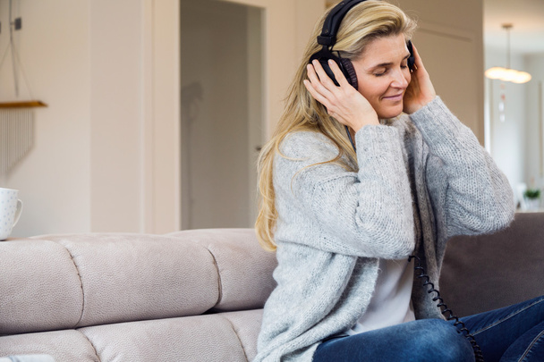 Nainen kuuntelemassa musiikkia kotona - Valokuva, kuva