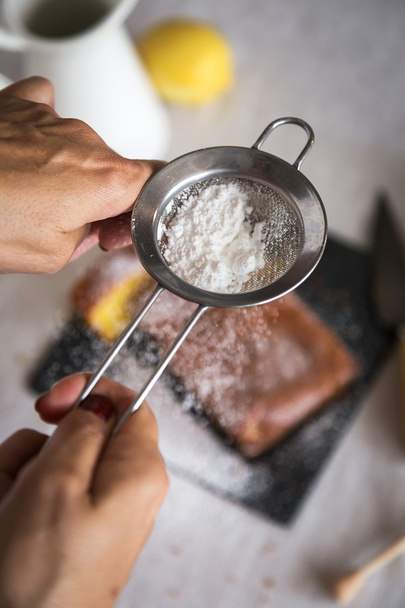 Woman powdering sugar on delicious cake - Zdjęcie, obraz