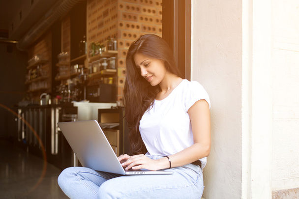 Female freelancer is keyboarding text message on laptop computer while work in coffe shop - Φωτογραφία, εικόνα