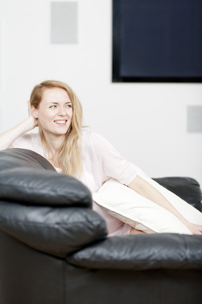 Young woman resting on sofa - Foto, afbeelding