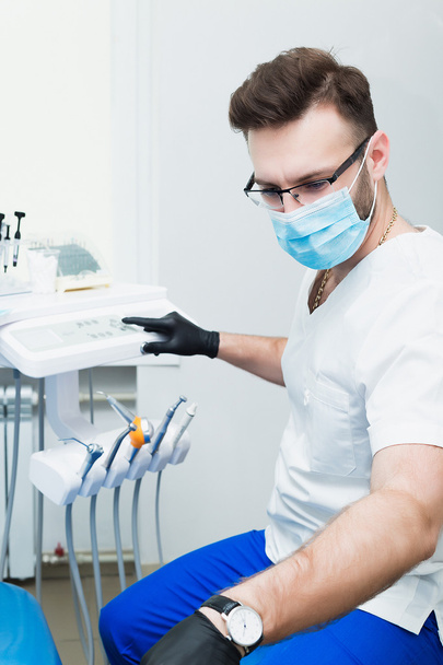 healthcare, profession, stomatology and medicine concept - smiling male young dentist over medical office background - 写真・画像