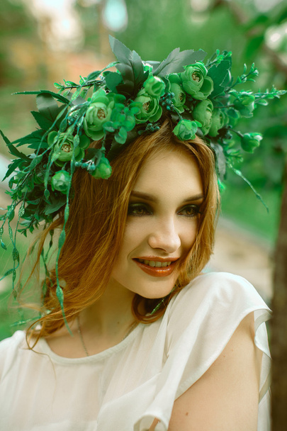 pretty woman with charming smile and wreath on head - Foto, Bild