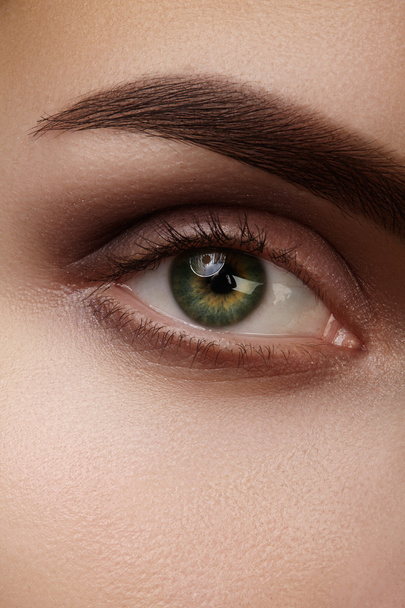 Bellissimo macro shot di occhio femminile verde con trucco naturale. Forma perfetta di sopracciglia, ombretti marroni e ciglia lunghe. Cosmetici e trucco. Primo piano macro scatto di moda smoky occhi visage
. - Foto, immagini