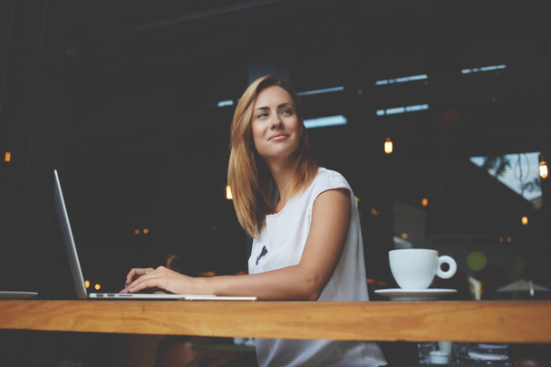 Kaunis nainen onnistunut freelancer käyttäen kannettavaa tietokonetta istuessaan kahvilassa
  - Valokuva, kuva