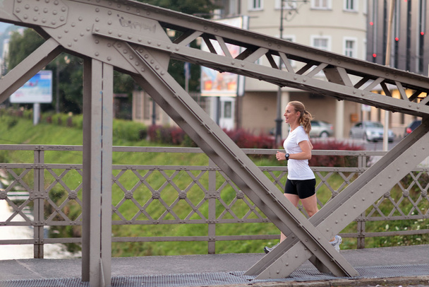 sporty woman running  on sidewalk - Photo, Image