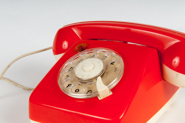 Ретро-помаранчевий телефон з поворотним циферблатом на білому
 - Фото, зображення