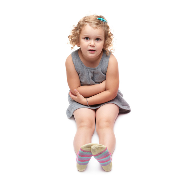 Young little girl sitting over isolated white background - Foto, Bild