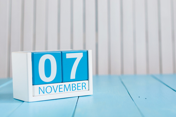7 ноября. Изображение деревянного календаря 7 ноября на синем фоне. Осенний день. Пустое место для текста
 - Фото, изображение