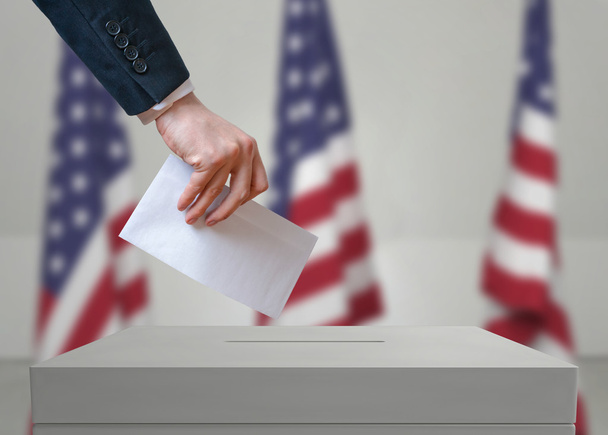 Volba ve Spojených státech amerických. Volební modul má obálku v ruce nad hlasovací hlasováním. - Fotografie, Obrázek