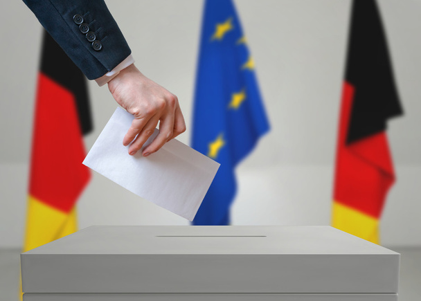 Election in Germany. Voter holds envelope in hand above vote ballot. - Photo, Image