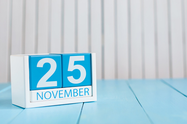 25 november. Foto van 25 november houten kleur kalender op blauwe achtergrond. Herfstdag. Lege ruimte voor tekst - Foto, afbeelding
