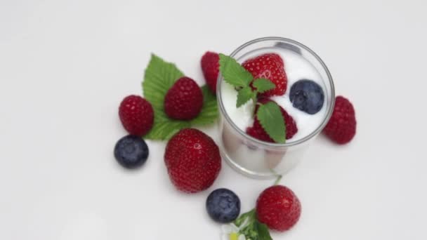 Yogur natural con bayas frescas girando aisladas sobre la luz natural y la luz del día
   - Metraje, vídeo