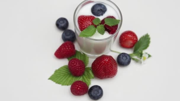 Jogurt naturalny z świeże jagody obrotowa na tle z i światło dzienne   - Materiał filmowy, wideo