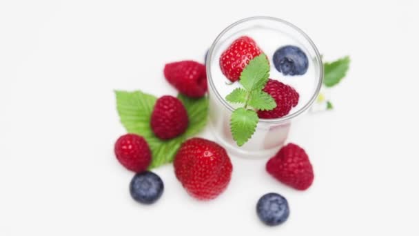 Natuurlijke yoghurt met verse bessen roterende geïsoleerd op met en daglicht   - Video