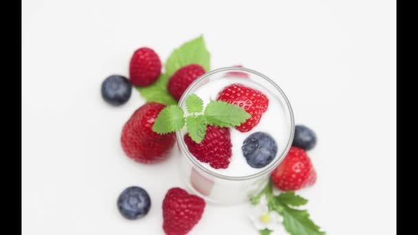 Jogurt naturalny z świeże jagody obrotowa na tle z i światło dzienne   - Materiał filmowy, wideo