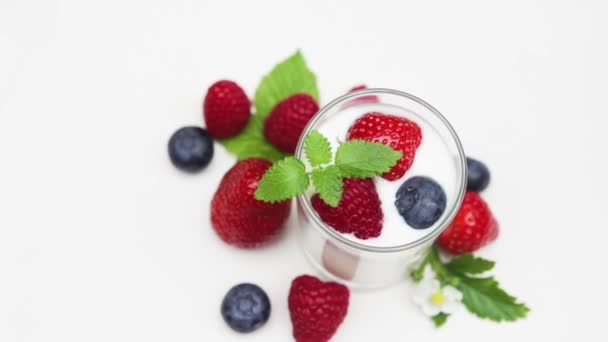 Přírodní jogurt s čerstvým ovocem rotující izolovaných na s a denní světlo   - Záběry, video