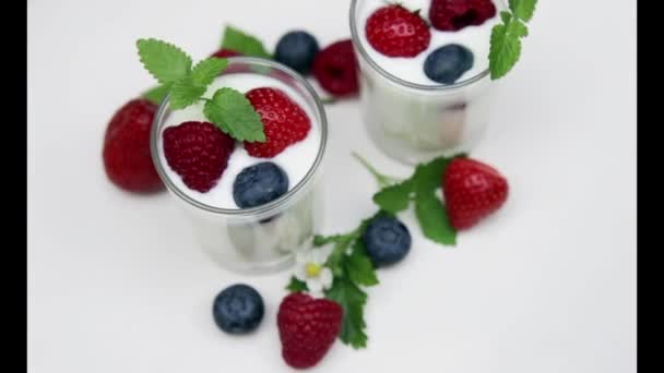 Természetes joghurt friss bogyós gyümölcsök, forgatható elszigetelt, és a nyári   - Felvétel, videó