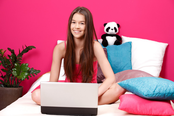 Teenager smiling and using laptop - Photo, Image