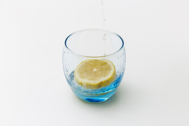 δροσιστικό ποτήρι νερό πιτσιλιστεί λεμόνι απομονώνονται σε Γουίτ - Φωτογραφία, εικόνα