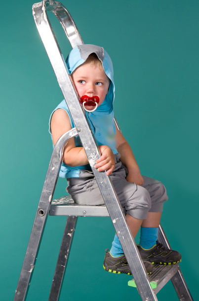 Boy sits on a ladder, in the hood - Photo, Image