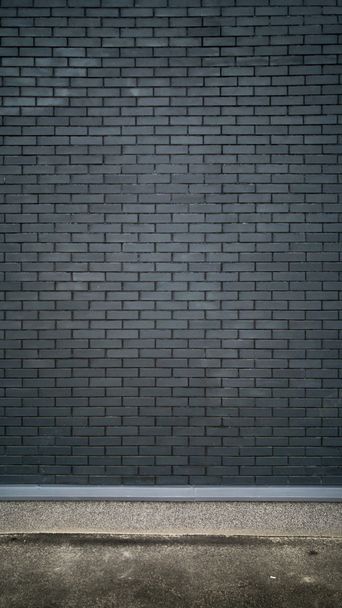Вертикальный кадр из черной кирпичной стены и бетонного пола
 - Фото, изображение