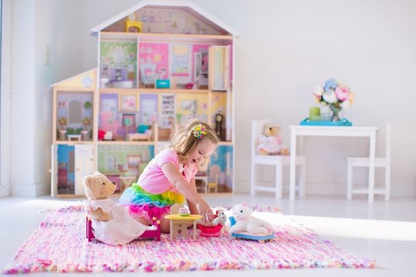 Niños jugando con peluches y casa de muñecas
 - Foto, imagen