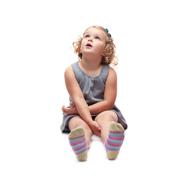 Young little girl sitting over isolated white background - Foto, Bild