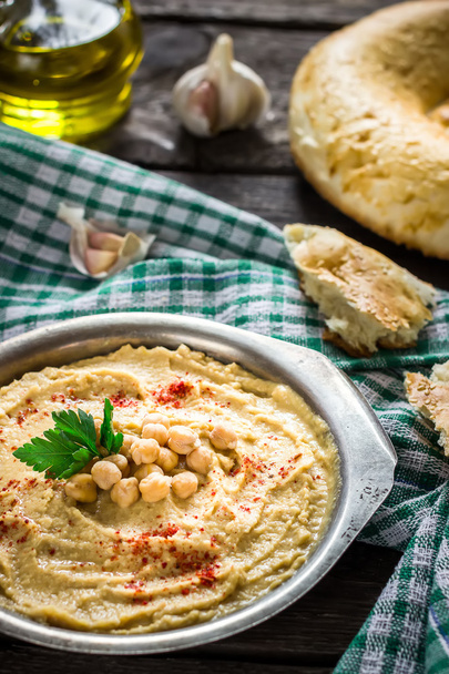 Hummus in metal bowl on  wooden table.  - Photo, Image