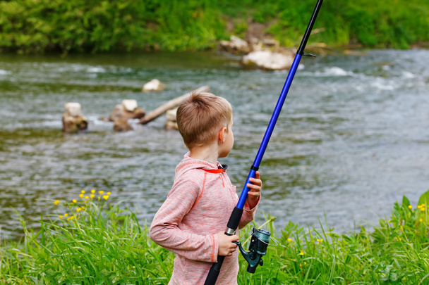 Cute small boy fishing on the river - Fotó, kép