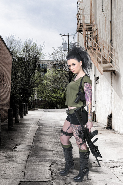Mujer tatuada con rifle de asalto
 - Foto, imagen