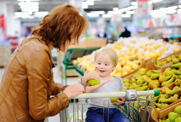 Young woman and her toddler son in a supermarket - Foto, Imagem
