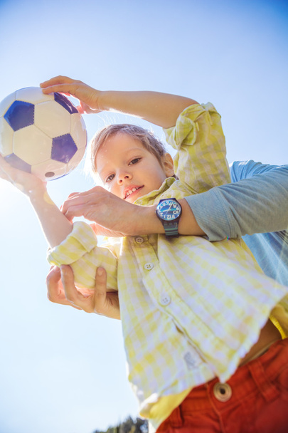 Niño sosteniendo pelota de fútbol
 - Foto, Imagen